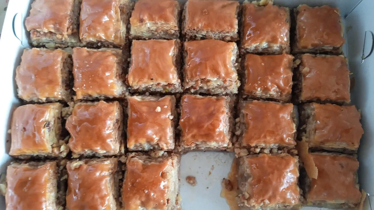 Squares of walnut baklava with visible layers of pastry and chopped nuts